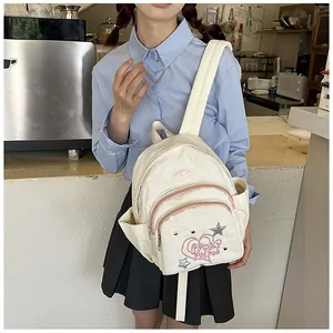 Détail du sac à dos en velours côtelé crème avec sequins cœur et étoile et poches latérales