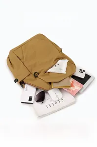 Internal view of khaki mini backpack showing multiple pockets and spacious storage space