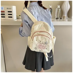 Mini sac à dos en velours côtelé blanc cassé avec imprimé cœur porté par un modèle