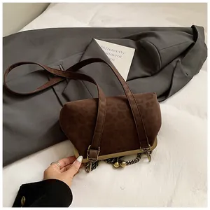 Détail du sac coquille en daim marron foncé à imprimé léopard avec fermoir en métal rétro