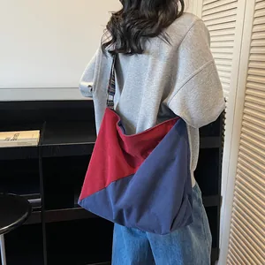 Contrast corduroy hobo bag in red and blue, large shoulder tote shown on female model