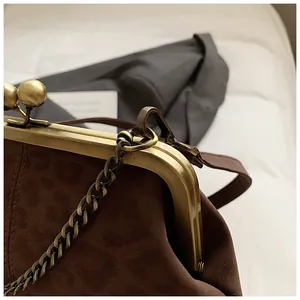 Détail du sac léopard vintage en cuir marron mat avec bandoulière dorée