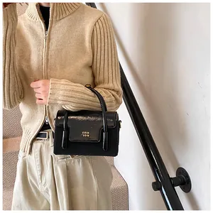 Detail view of the black crossbody bag with gold hardware and stylish metal accents