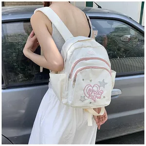 Détail d'un mini sac à dos en velours côtelé blanc avec broderie cœur rose et étoile
