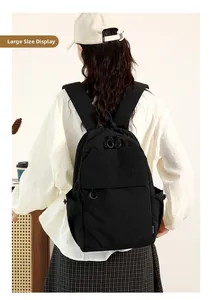 Detail of a large black waterproof nylon backpack shown from the back on a person