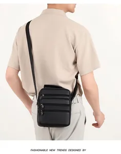 Rear view of man wearing a black pebble leather crossbody bag with three zipper pockets