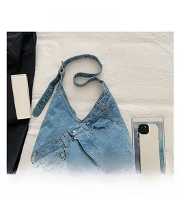 Detailed view of the washed denim shoulder bag with creative jean-style pocket design