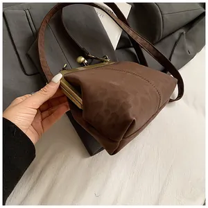 Gros plan du fermoir en métal bronze et de la texture léopard sur le sac à main en daim brun