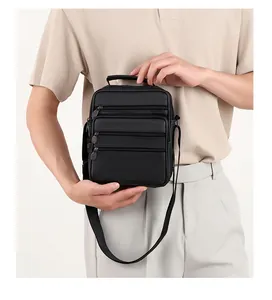 Detailed view of black genuine leather shoulder bag showing multiple zipper compartments