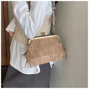 Zijaanzicht van bruine crossbodytas met franjes, suèdetextuur en boho-schouderriem