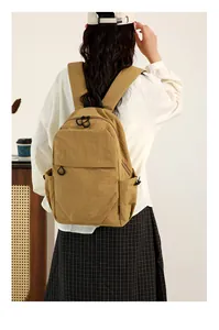 Khaki mini waterproof backpack shown on a person for size and scale reference