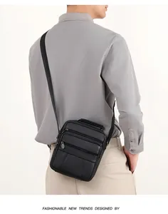 Close-up of black leather business crossbody bag with multi-layer zippers and top handle