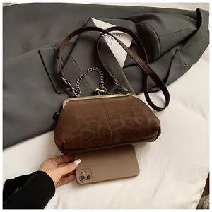 Détail d'une pochette rétro en forme de coquille avec texture léopard et fermoir doré
