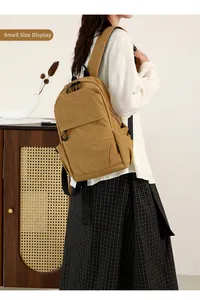 Small nylon backpack in mustard yellow featuring a functional front zipper pocket