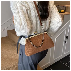 Détail d'un sac à main léopard avec fermoir en bronze et bandoulière sur un mannequin