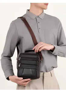 Close-up of dark coffee leather crossbody bag with multiple zippers and textured finish