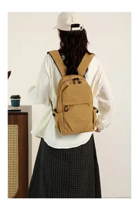 Mini yellow nylon backpack styled in a casual setting for daily travel and outdoor use