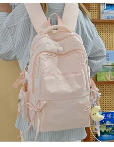 Dettaglio zaino scolastico in nylon rosa con ricamo e ciondolo a luna in peluche soffice
