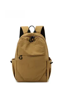 Front view of a mustard yellow waterproof nylon mini backpack with black ring zipper pulls