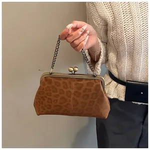 Détail du sac de soirée en daim léopard avec fermoir kiss-lock doré et chaîne