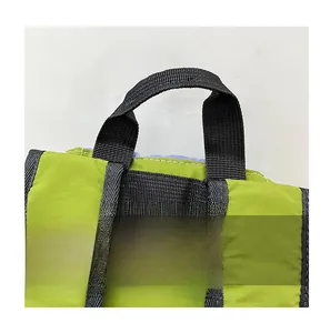 Detail of a durable black nylon handle on a lightweight green drawstring backpack