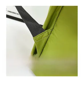 Detail shot of reinforced triangle stitching on green nylon backpack shoulder straps