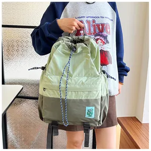 Detail of color-block drawstring backpack showing nylon texture and blue leaf patch