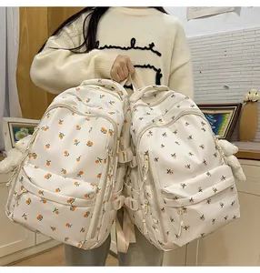 Detail of a large capacity backpack showing fruit and floral prints with side buckles