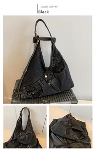 Detail of black denim shoulder bag featuring jeans-style waist details and metal buttons