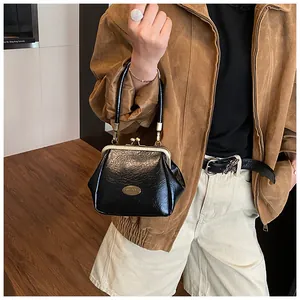 Détail du sac à main plissé noir avec cadre métallique doré et fermoir rétro chic