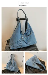 Detail of light blue denim shoulder bag featuring classic jeans pockets and metal buttons