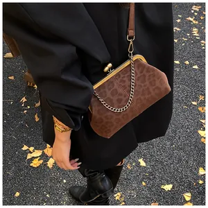 Détail du sac coquille léopard avec fermoir baiser doré et bandoulière chaîne chic