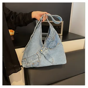 Detail of washed denim shoulder bag featuring jeans waistband design and metal buttons