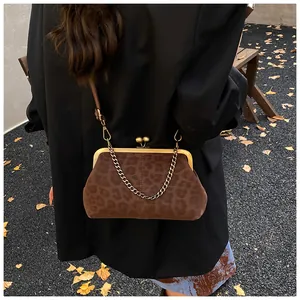 Vue street style d'un sac coquille à imprimé léopard avec une bandoulière en chaîne dorée