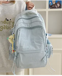 Dettaglio dello zaino celeste con ricamo 'Have a nice day' e tasche laterali