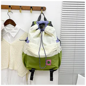 Detail of multi-color drawstring backpack with floral patch and striped ropes