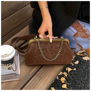 Vue détaillée de la texture léopard sur un sac vintage marron avec un cadre en métal doré