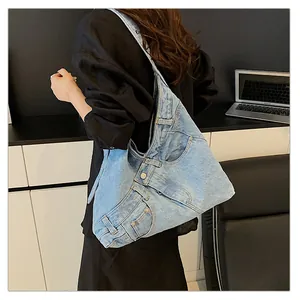 Detail of light blue denim tote bag with reconstructed jeans pockets and metal rivets