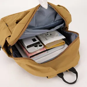 Compact dark camel nylon mini backpack showing large capacity interior with tablet and books