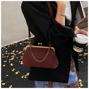 Détail du sac coquille bordeaux à motif léopard avec fermoir bronze et chaîne vintage