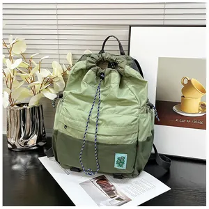 Detail showing light green drawstring backpack with nylon texture on white window background