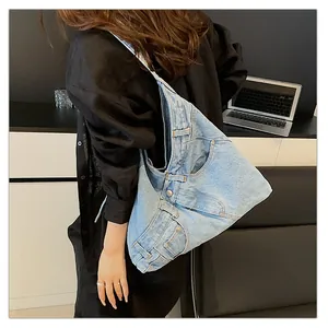 Detailed view of light blue denim shoulder bag featuring jeans-style waist and pocket design