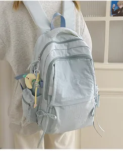 Dettaglio dello zaino celeste con ricamo e ciondolo a forma di luna in morbido peluche