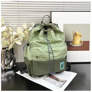 Detail of green nylon drawstring backpack with waterproof texture and woven cords