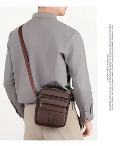 Gros plan sur le cuir marron grainé et les poches multiples de cette sacoche pour hommes