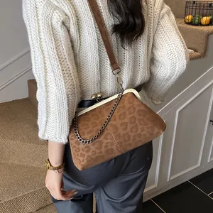 Sac de soirée vintage léopard avec fermoir doré et chaîne présenté sur modèle