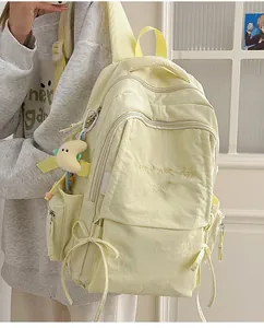 Dettaglio dello zaino scolastico giallo con ricamo e ciondolo a forma di luna di peluche