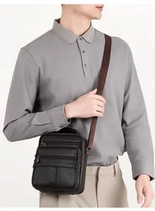 Détail du sac bandoulière en cuir marron foncé avec plusieurs poches zippées sur un mannequin