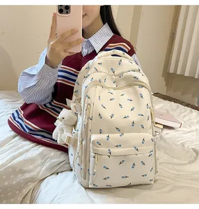 Detail of floral print backpack with side buckle and cute bear plush charm