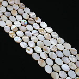 Dettaglio macro di perle ovali in madreperla naturale cangiante su sfondo nero